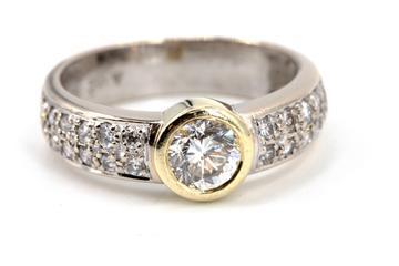 Vorschaubild: Goldring mit brillantbesetztem Band und zentralem Diamanten.
