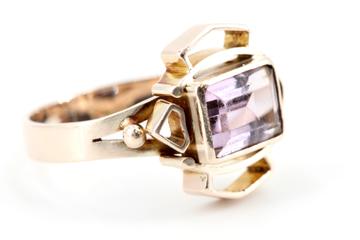Vorschaubild: Goldring mit rechteckigem lila Stein und geometrischen Details.